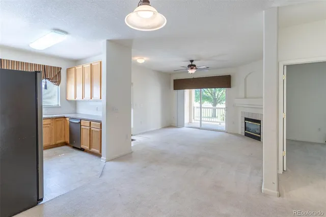 a view of a kitchen with a sink and dishwasher a refrigerator with white cabinets