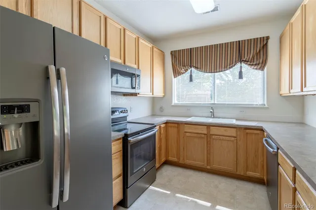 a kitchen with stainless steel appliances granite countertop a refrigerator sink and microwave