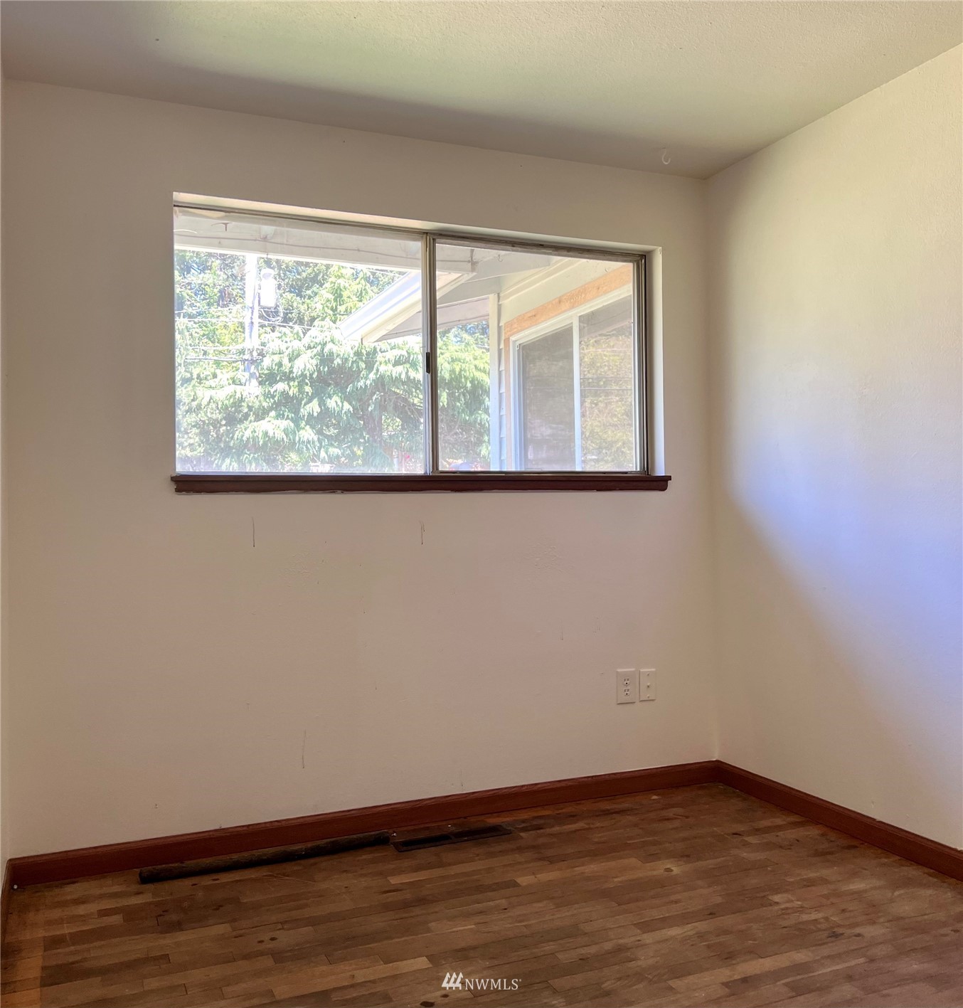 1166 Brookdale Road East Tacoma, WA 98445 - Photo 7 of 20 a view of an empty room with wooden floor and a window