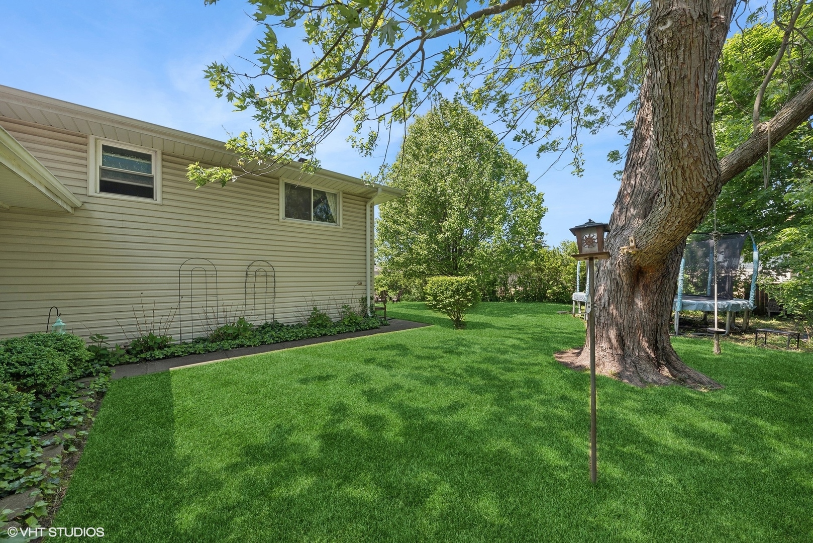 750 Leaf Court Bartlett, IL 60103 - Photo 16 of 17 a view of a backyard with plants and a large tree