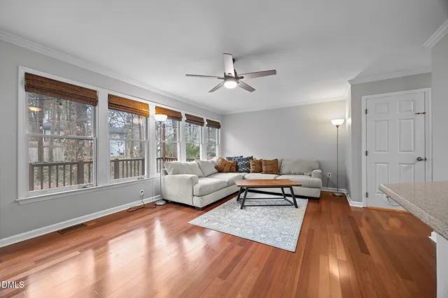 a view of an empty room with wooden floor fireplace and a window
