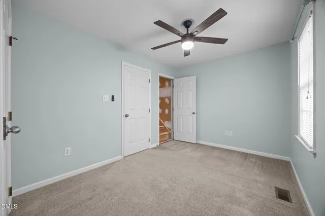an empty room with chandelier fan