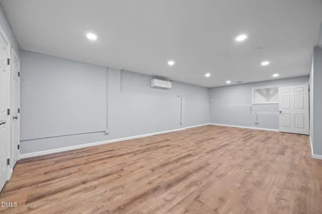 a view of empty room with wooden floor and window