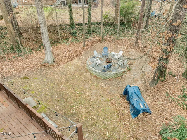a backyard of a house with wooden deck table and chairs