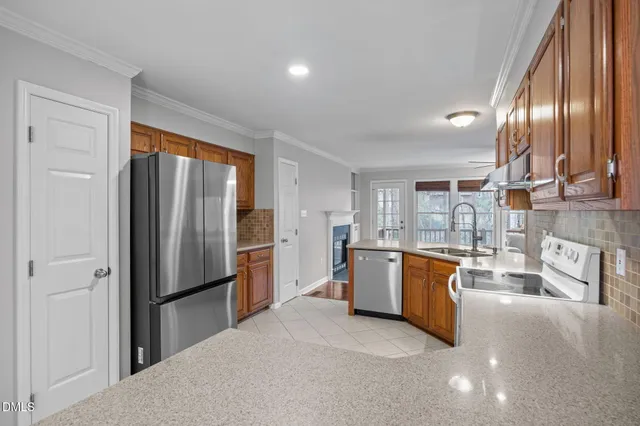 a kitchen with stainless steel appliances granite countertop a refrigerator sink and stove