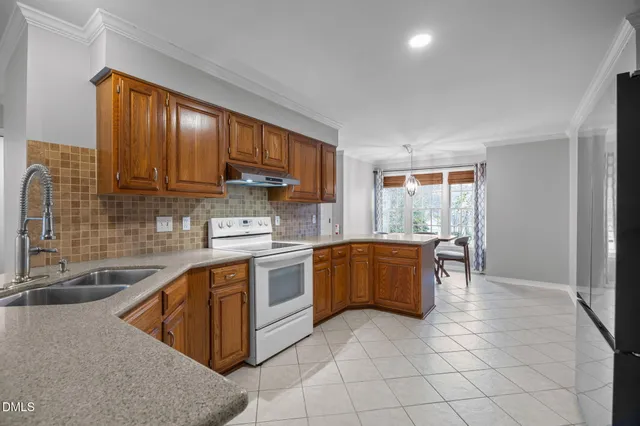 a kitchen with stainless steel appliances granite countertop a stove sink and cabinets