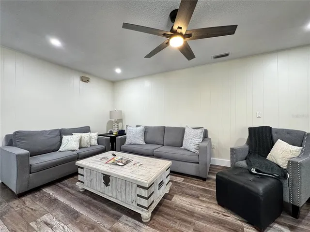 a living room with furniture and a wooden floor