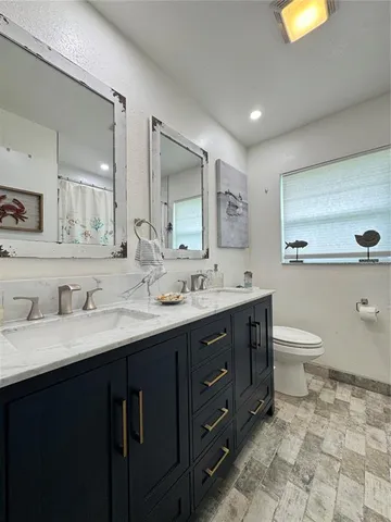 a bathroom with a granite countertop sink mirror and a bathtub