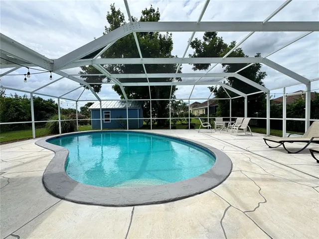 a view of a swimming pool with a patio and garden