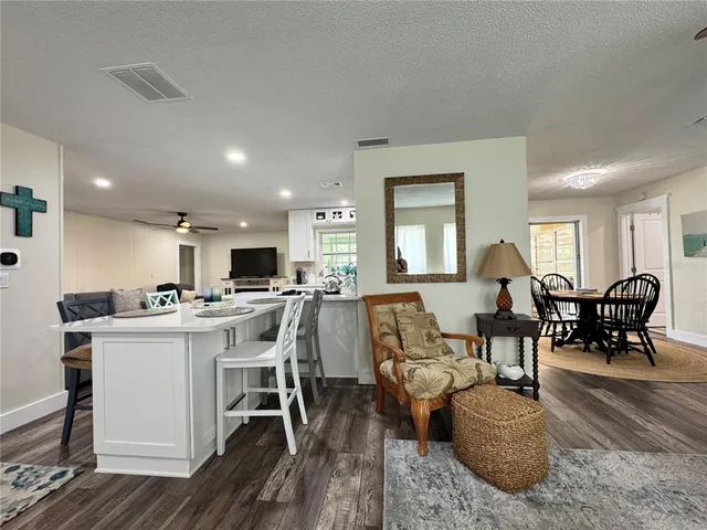 a dining room with furniture a chandelier and wooden floor