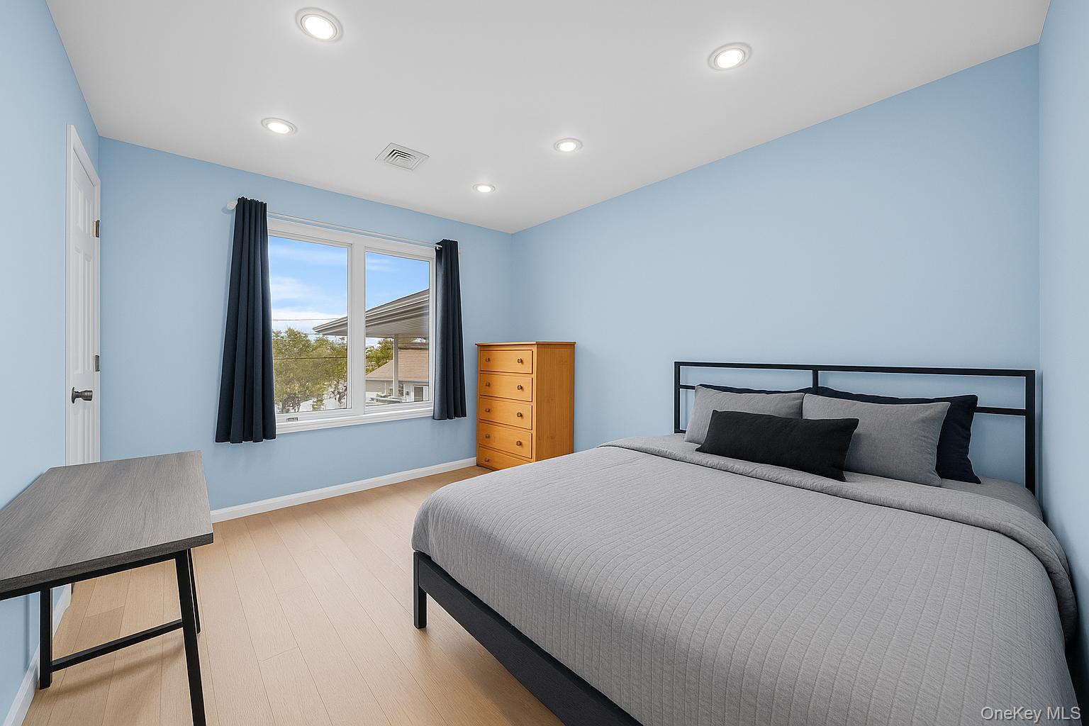 Undisclosed Address Freeport, NY 11520 - Photo 13 of 22 a bedroom with a large bed and a large window