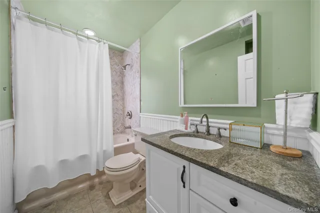 a bathroom with a granite countertop sink a toilet and a mirror