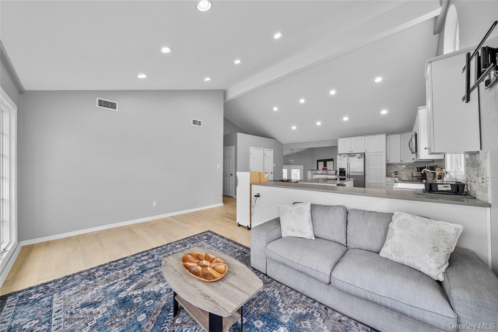 Undisclosed Address Freeport, NY 11520 - Photo 7 of 22 a living room with kitchen island furniture and a view of kitchen