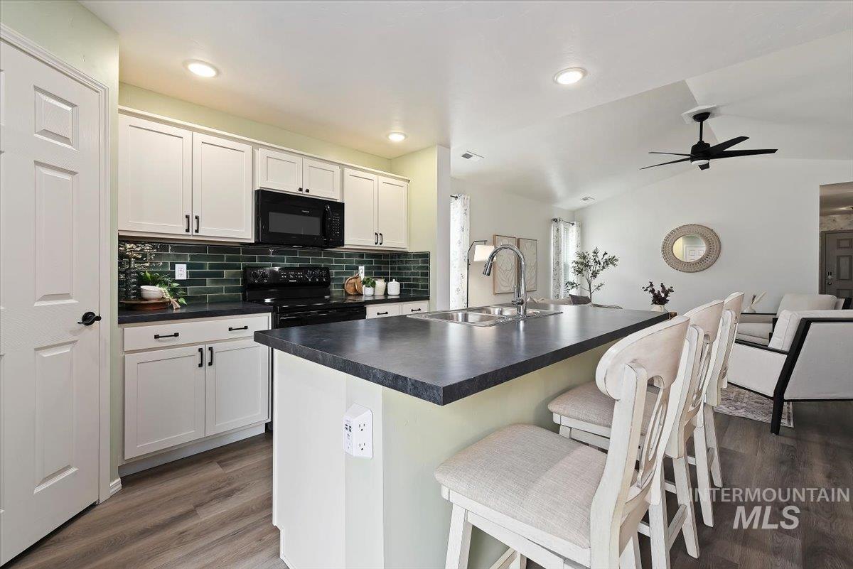 12781 Ashfield Street Caldwell, ID 83607 - Photo 10 of 36 Dining area featuring wallpapered walls, a wainscoted wall, dark wood-style flooring, suspended lighting, and wooden walls
