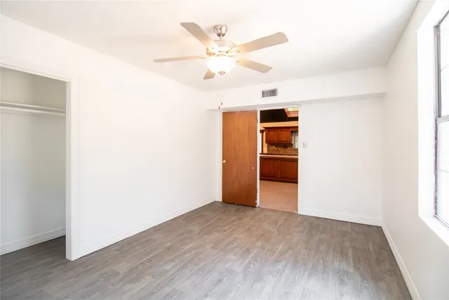 an empty room with closet and windows