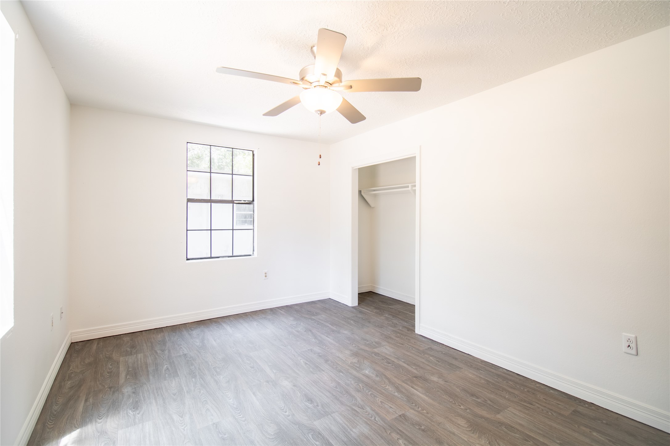 27607 Decker Woods Drive Magnolia, TX 77354 - Photo 19 of 48 an empty room with wooden floor fan and windows