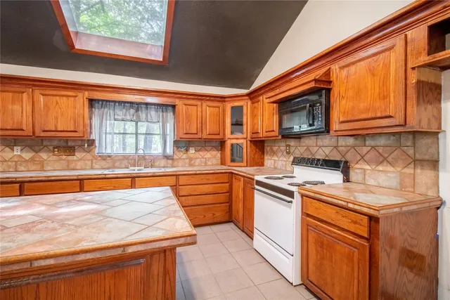 a kitchen with stainless steel appliances granite countertop wooden cabinets a sink and a stove