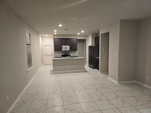 a large kitchen with a stove a refrigerator and a sink