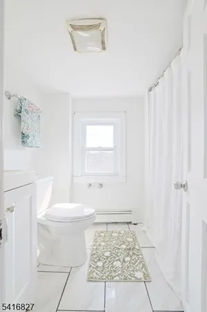 a bathroom with a toilet a sink and a window