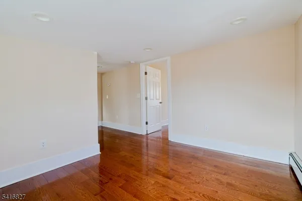 a view of an empty room with wooden floor