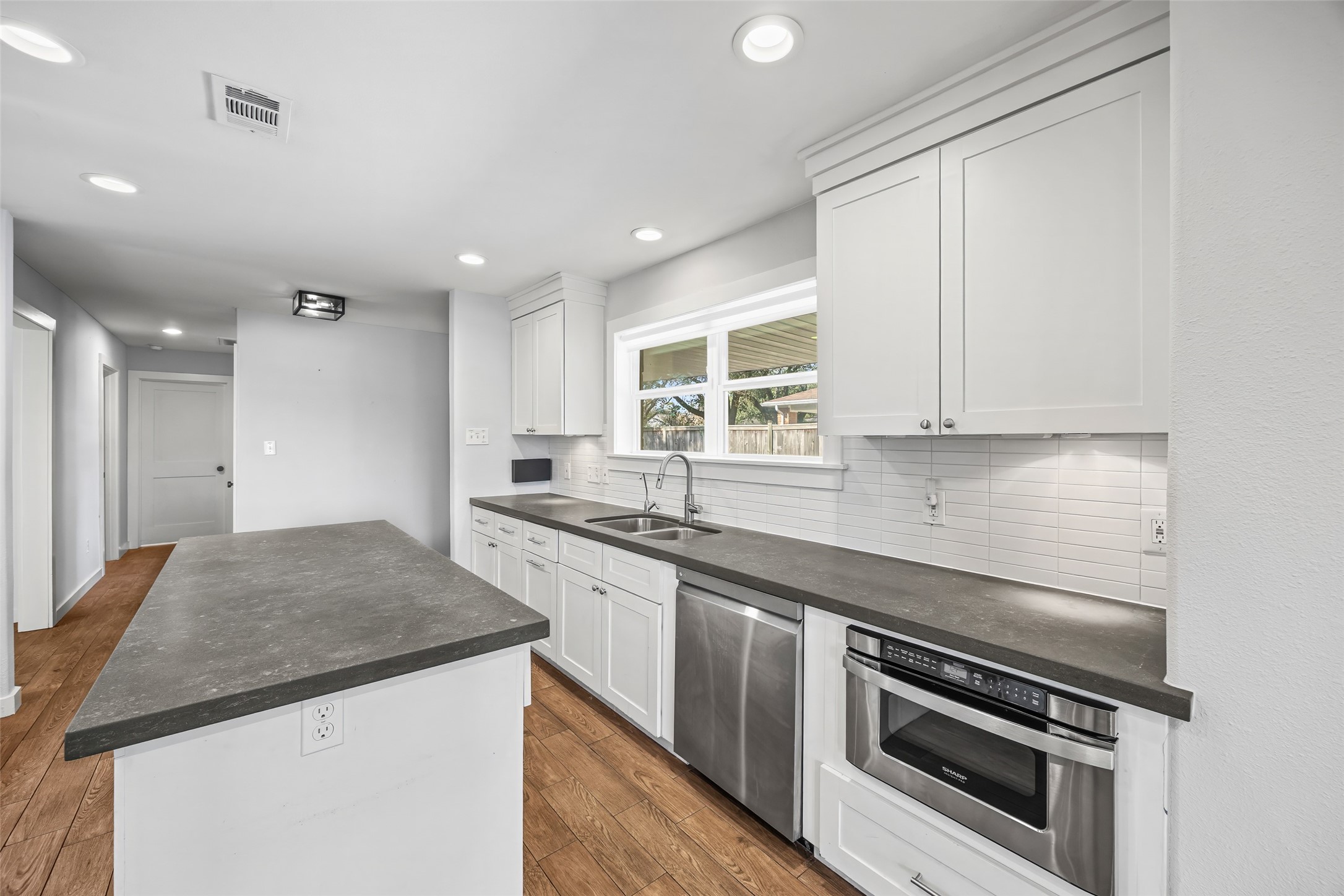 9715 Greenwillow Street Houston, TX 77096 - Photo 11 of 31 a kitchen with granite countertop a sink stainless steel appliances and white cabinets