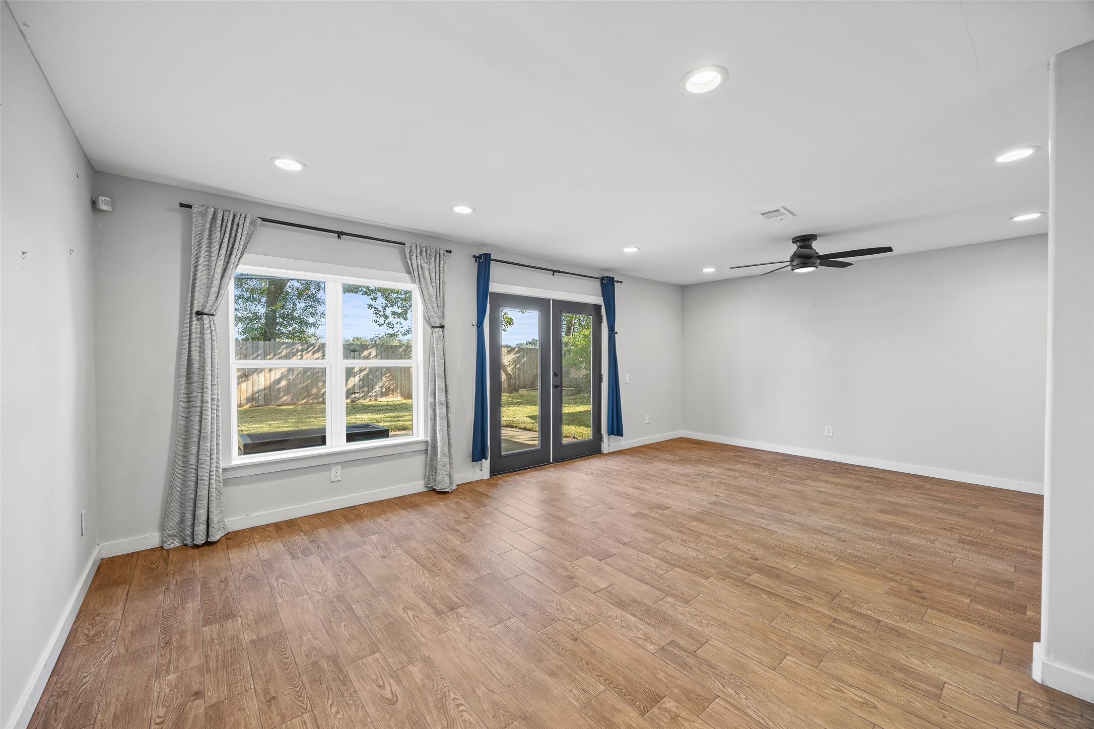 9715 Greenwillow Street Houston, TX 77096 - Photo 13 of 31 a view of an empty room with a window and wooden floor