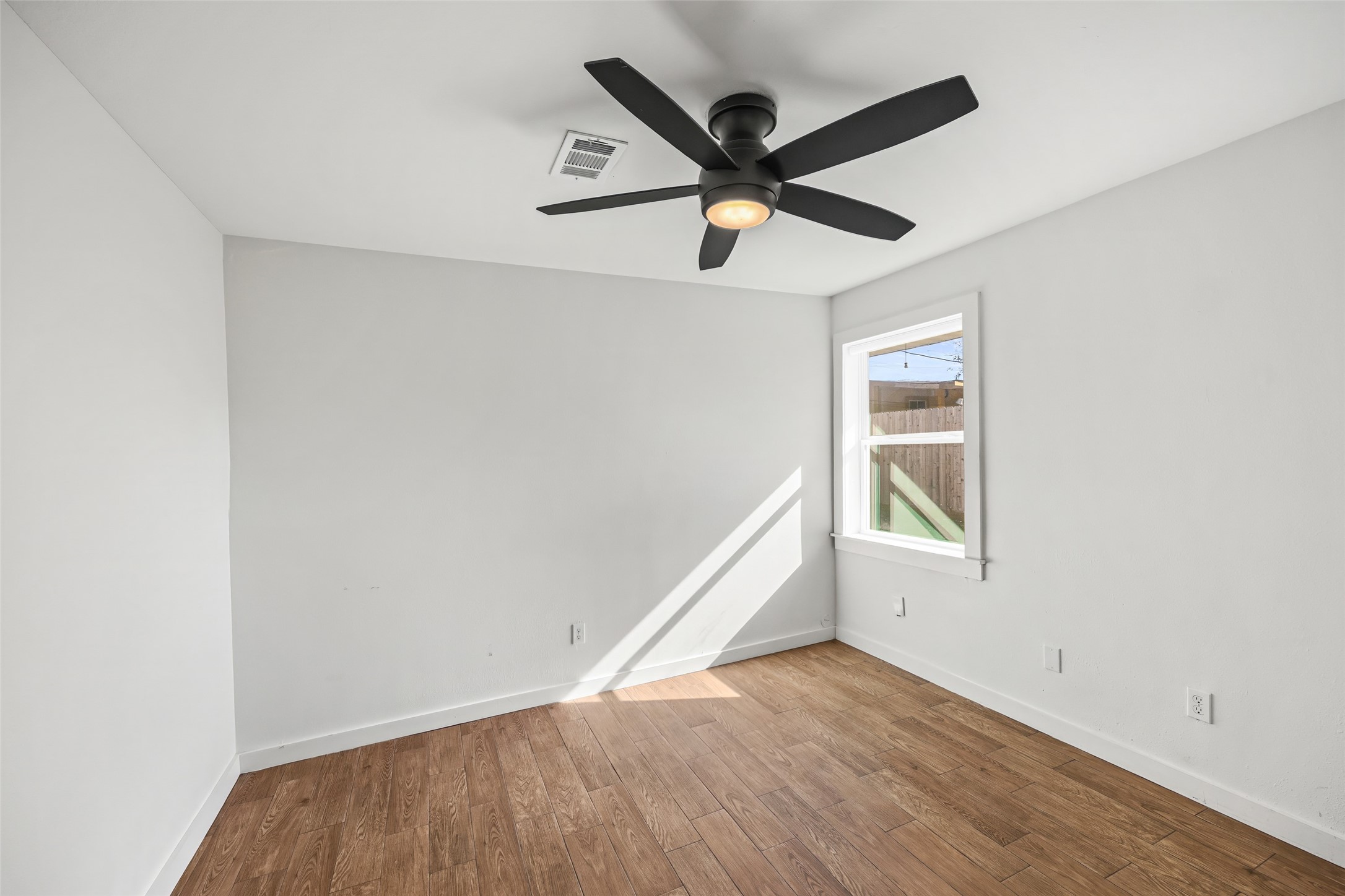 9715 Greenwillow Street Houston, TX 77096 - Photo 16 of 31 an empty room with wooden floor and windows