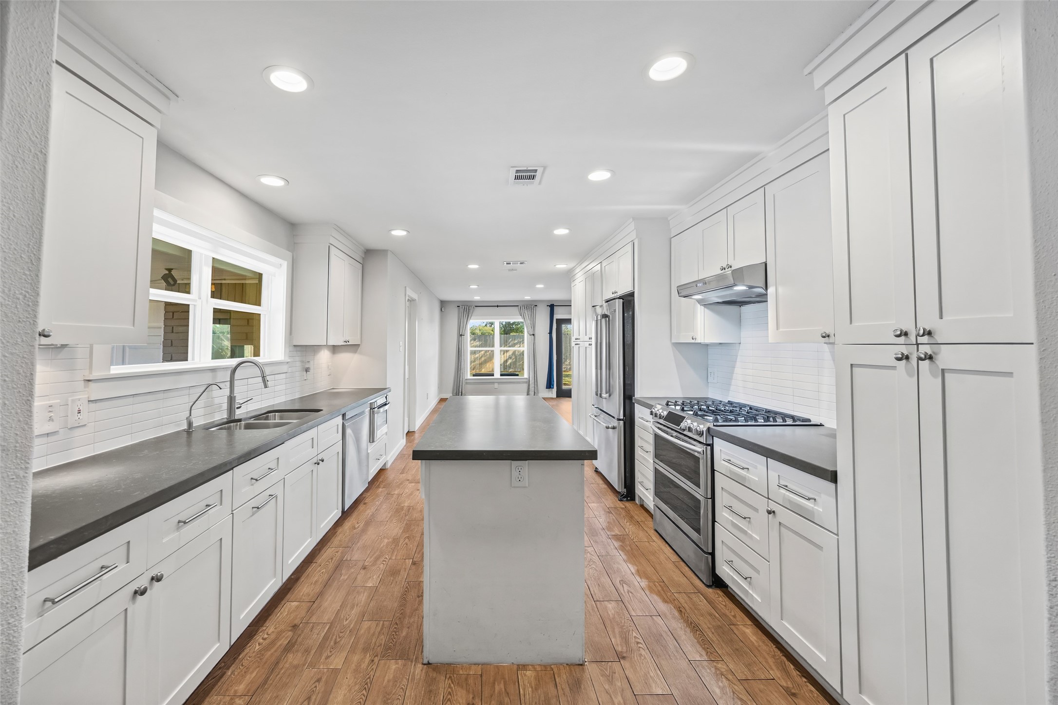 9715 Greenwillow Street Houston, TX 77096 - Photo 5 of 31 a large kitchen with granite countertop a large counter top space a sink stainless steel appliances and cabinets