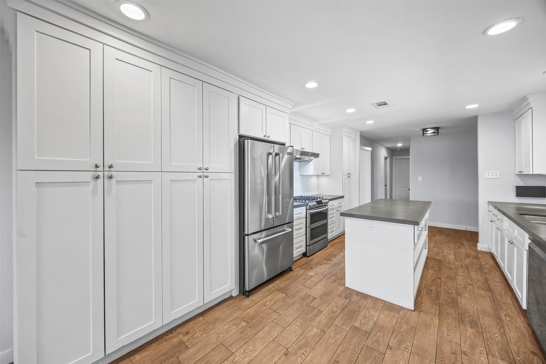 9715 Greenwillow Street Houston, TX 77096 - Photo 10 of 31 a kitchen with a refrigerator a sink and cabinets