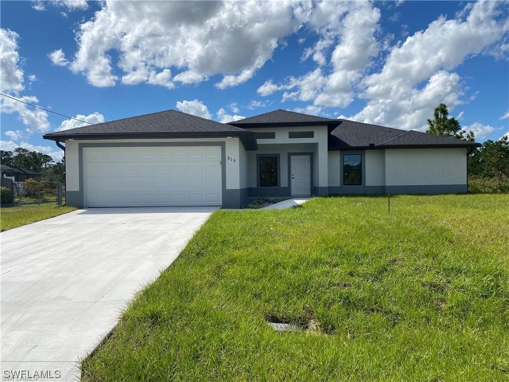 a front view of a house with a yard and garage