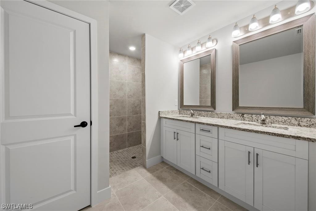 220 Grant Avenue Lehigh Acres, FL 33936 - Photo 6 of 6 a bathroom with a double vanity sink and a mirror