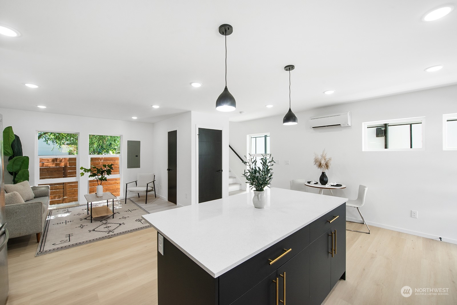 9004 15th Avenue Southwest, Unit A Seattle, WA 98106 - Photo 9 of 20 a kitchen with stainless steel appliances kitchen island granite countertop a refrigerator a sink a dining table and chairs with wooden floor