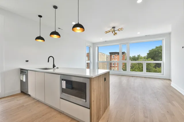 a view of a kitchen sink a stove and wooden floor