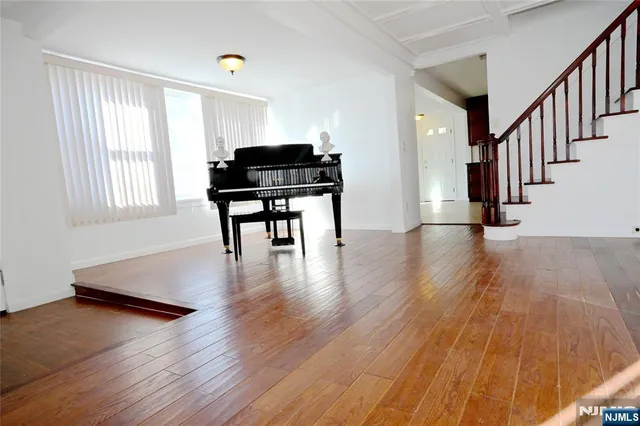 a livingroom with wooden floor and black white walls