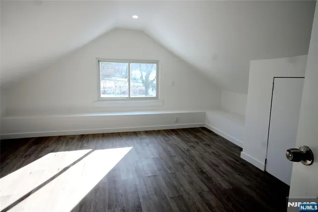 a view of a room with wooden floor and a window
