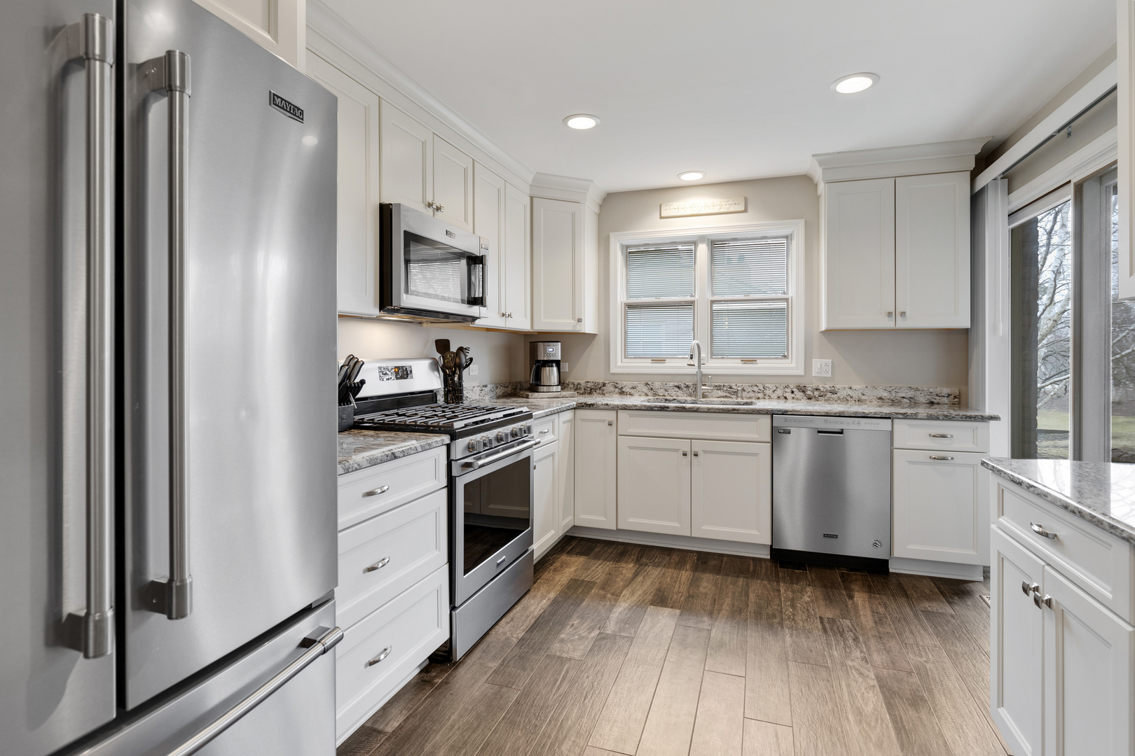 1805 Ashbury Lane, Unit 1805 Inverness, IL 60067 - Photo 3 of 21 a kitchen with granite countertop appliances cabinets and a wooden floor