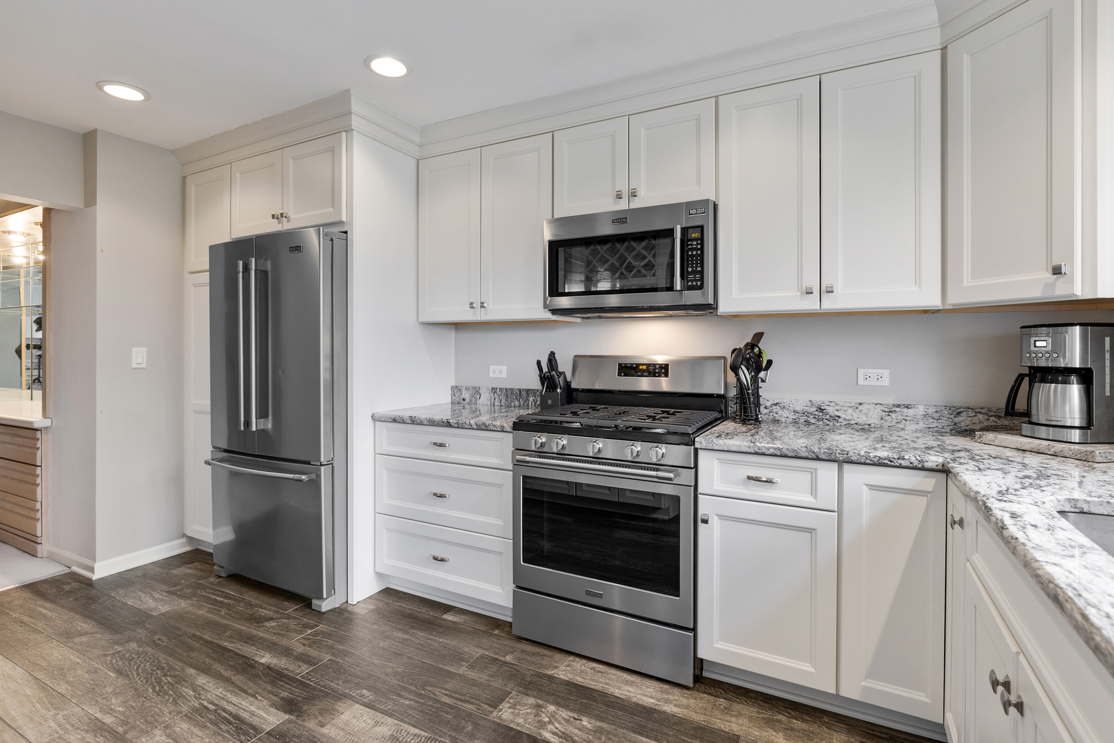 1805 Ashbury Lane, Unit 1805 Inverness, IL 60067 - Photo 5 of 21 a kitchen with stainless steel appliances granite countertop a refrigerator stove and white cabinets