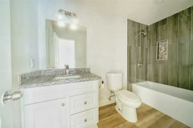 a bathroom with a granite countertop sink toilet and shower