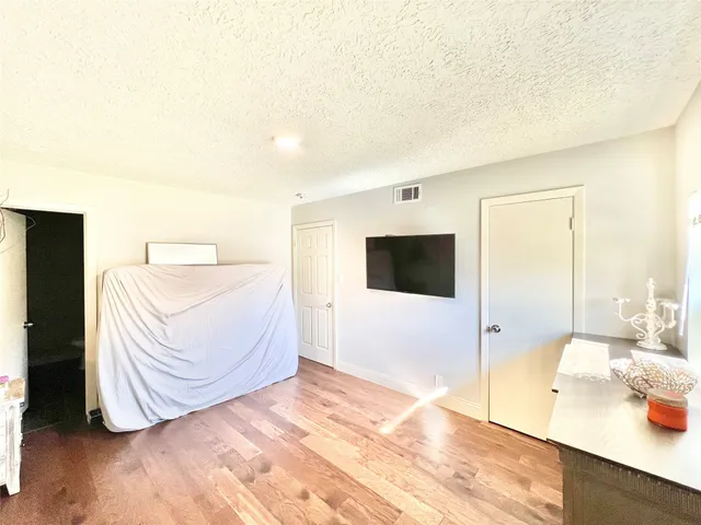 a spacious bedroom with a bed and a flat screen tv