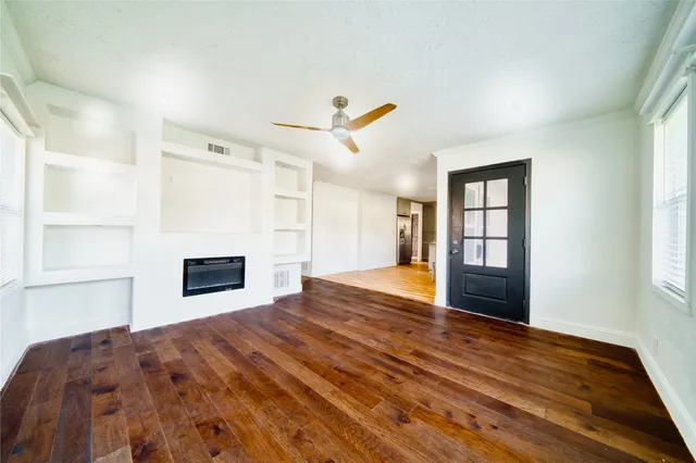 a view of a livingroom with wooden floor and a window