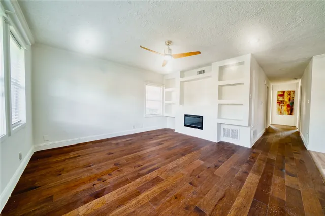 a view of a livingroom with wooden floor and staircase