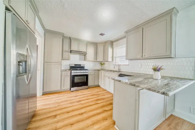 a kitchen with a sink stove and refrigerator