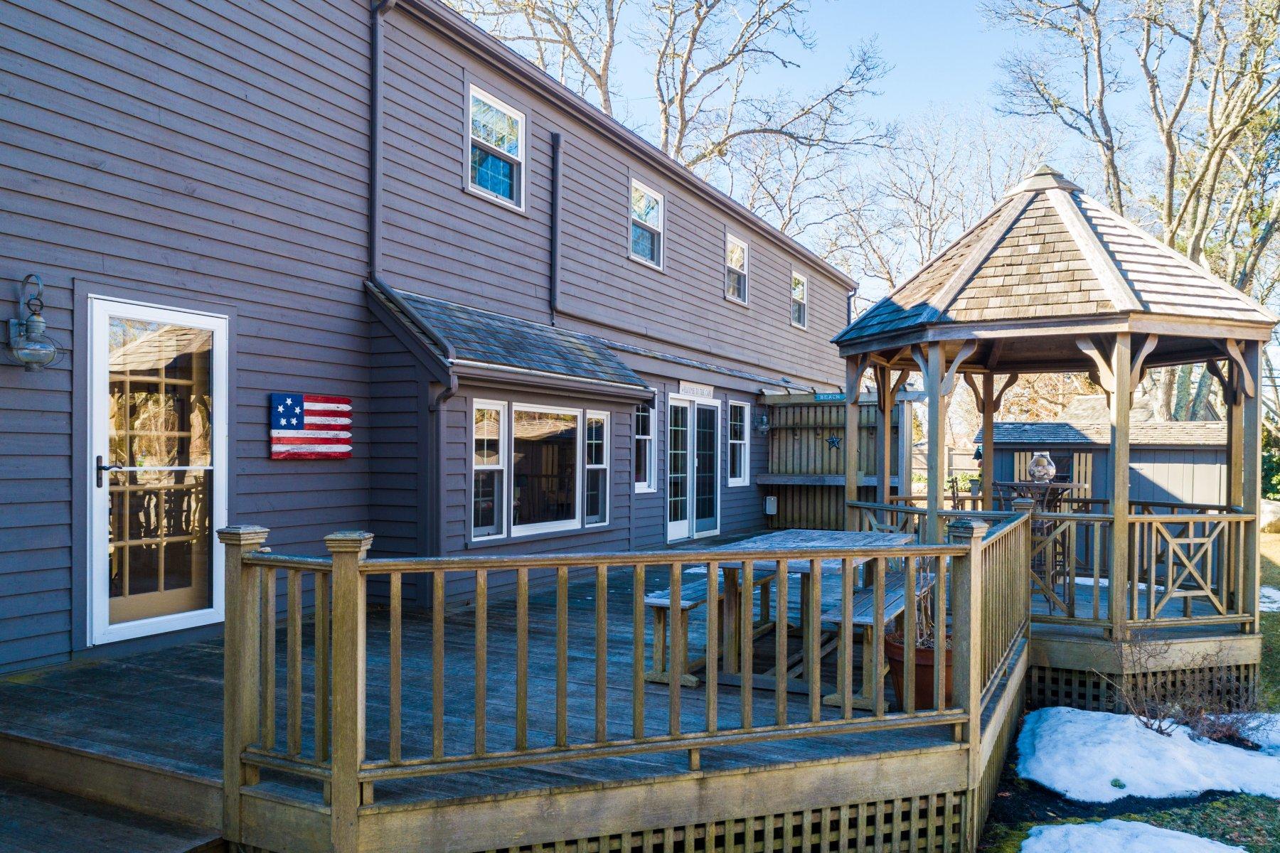 4 Shapquit Bars Road Falmouth, MA 02540 - Photo 29 of 45 a view of a brick house with large windows and a table