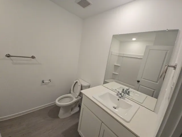 a bathroom with a toilet sink and mirror