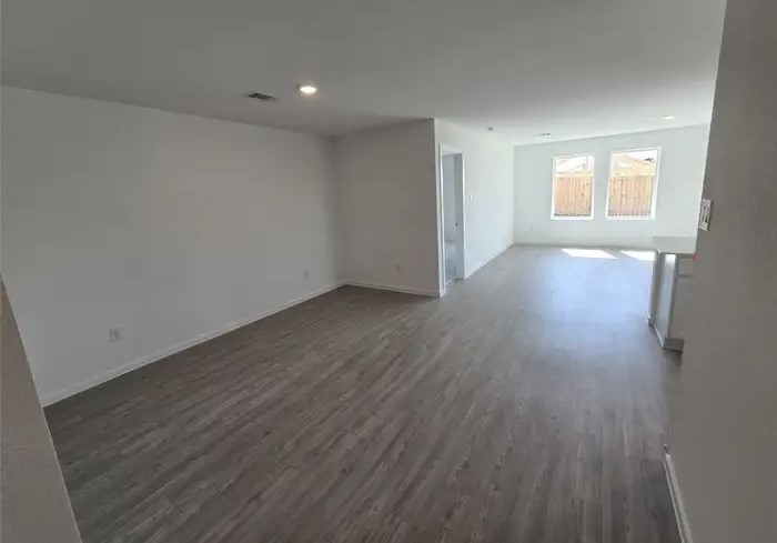 16059 Tallis Drive Conroe, TX 77303 - Photo 10 of 10 an empty room with wooden floor and windows