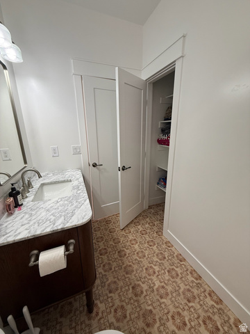 3550 North River Ln Road East Panguitch, UT 84759 - Photo 8 of 25 Bathroom featuring a patterned tile floor, a dark wood-finish vanity with a white marble countertop, an undermount sink, and a brushed nickel faucet