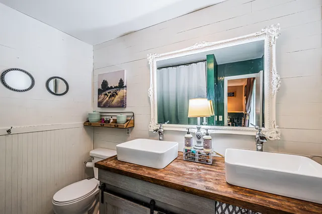 a bathroom with a granite countertop sink vanity mirror and toilet
