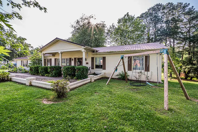 a view of a house with a backyard and a tree