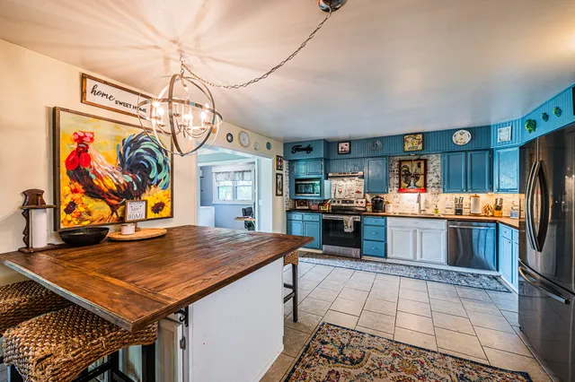 a view of a kitchen with stainless steel appliances granite countertop a stove and cabinets