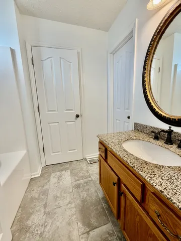 a bathroom with a granite countertop sink and a mirror